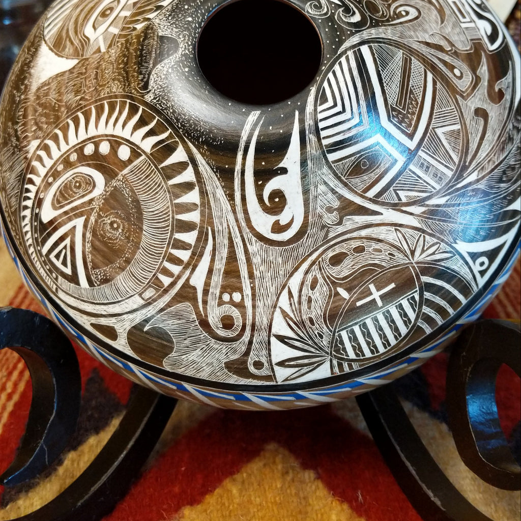 White clay with brown accents carved with detailed eyes and intricate designs.