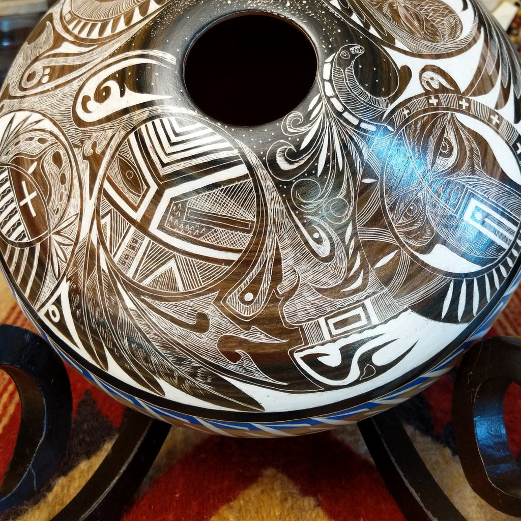 White clay with brown accents carved with detailed eyes and intricate designs.