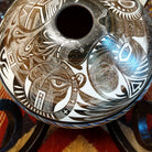 White clay with brown accents carved with detailed eyes and intricate designs.