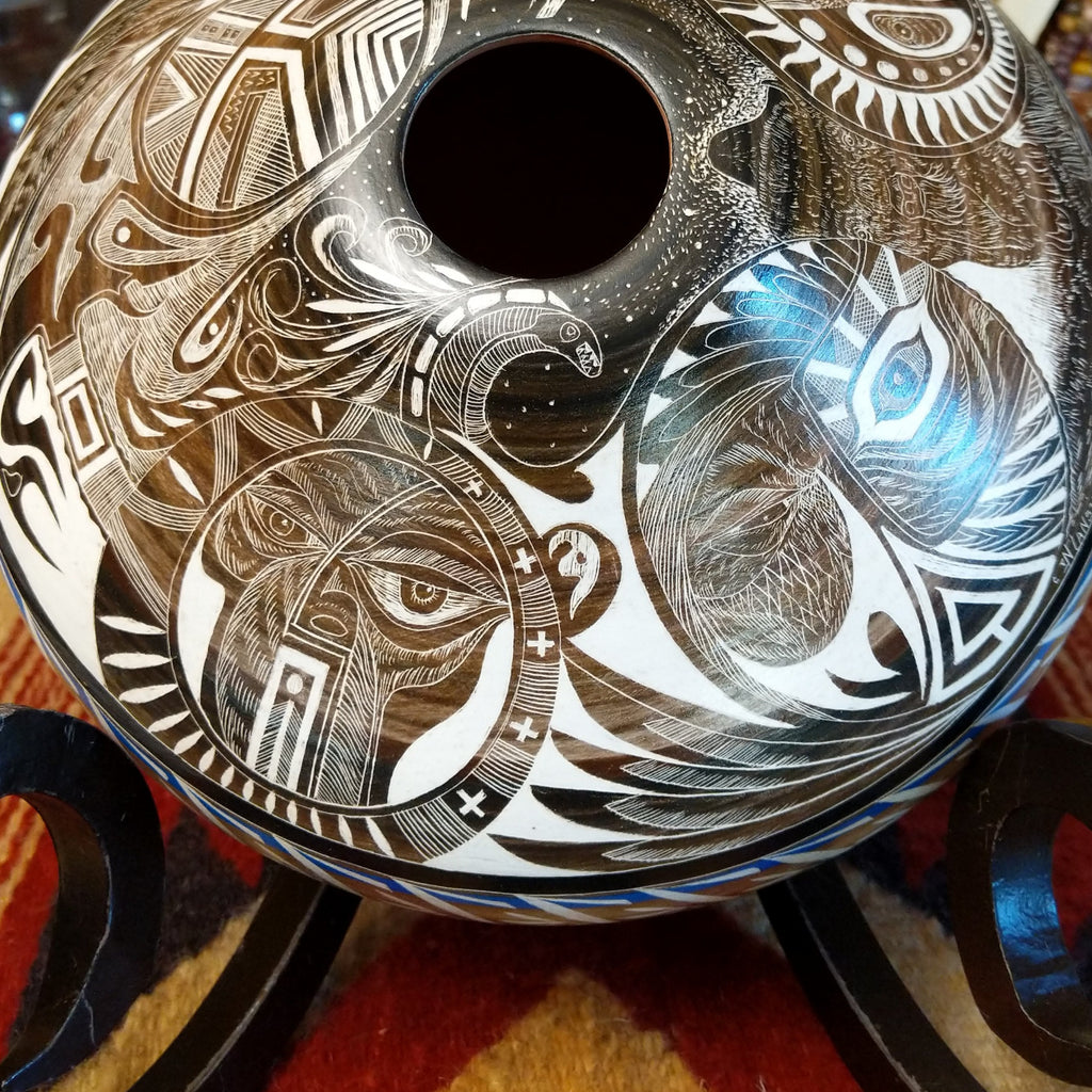 White clay with brown accents carved with detailed eyes and intricate designs.