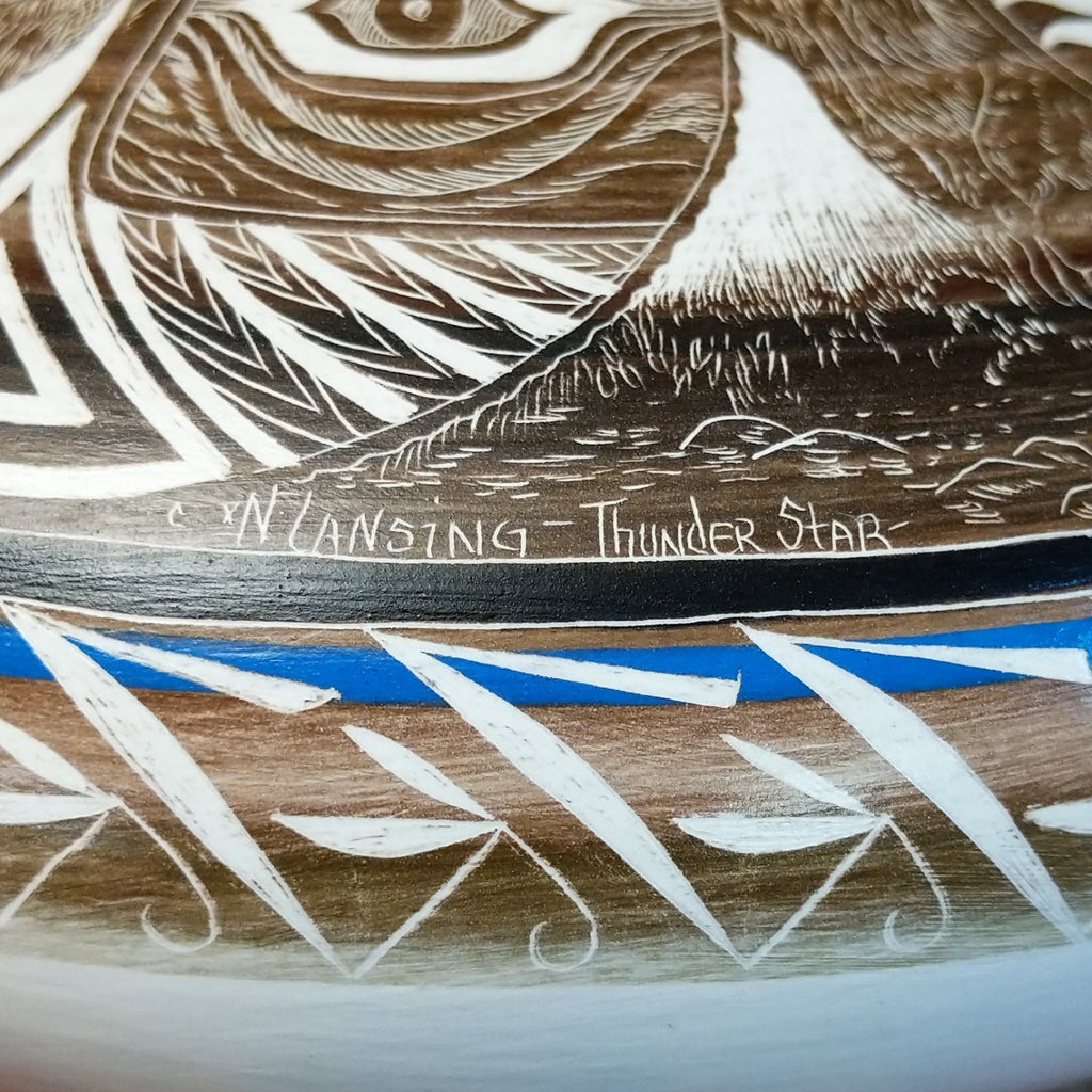 A close-up of the artisan's signature and title of the piece.