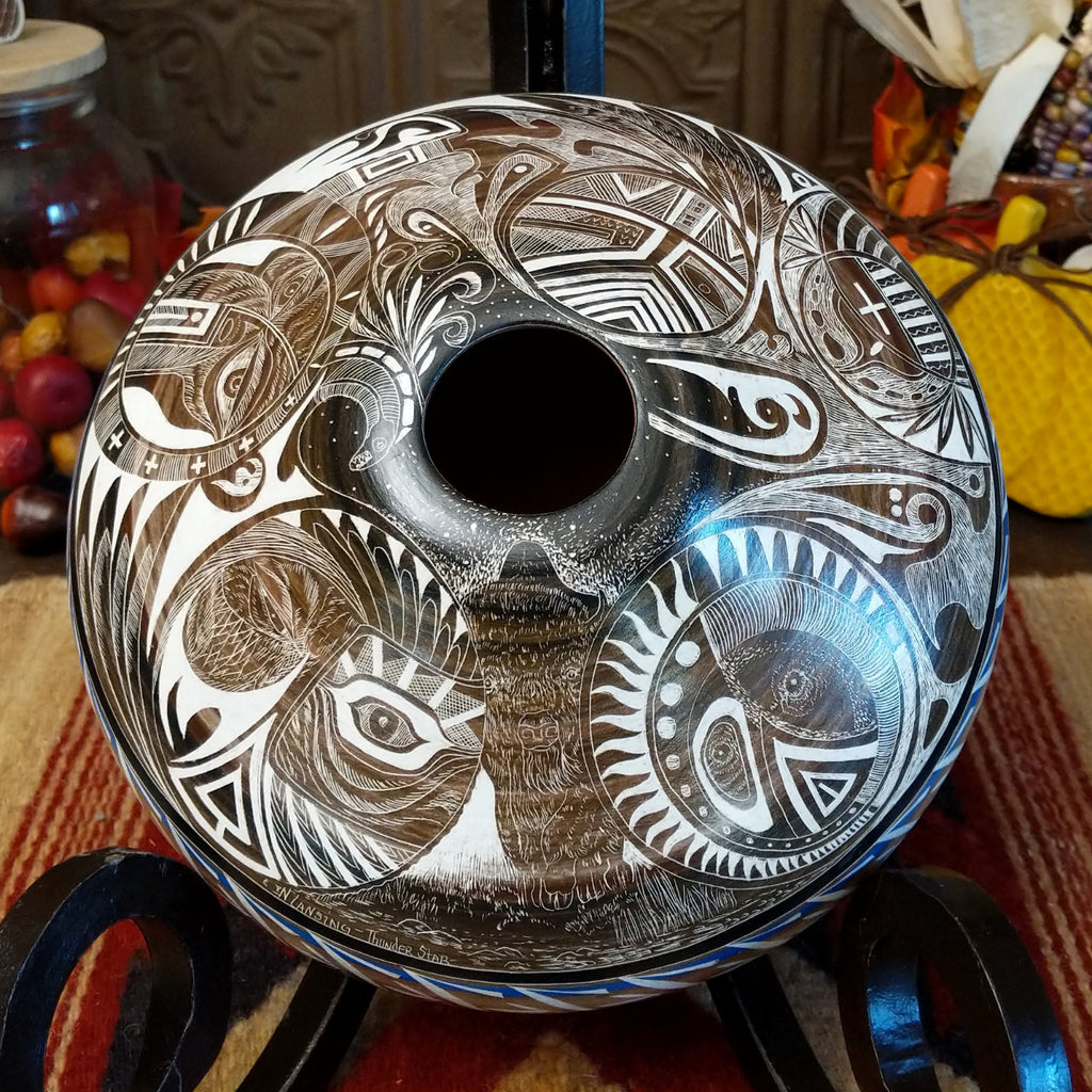 White clay with brown accents carved with detailed eyes and intricate designs.