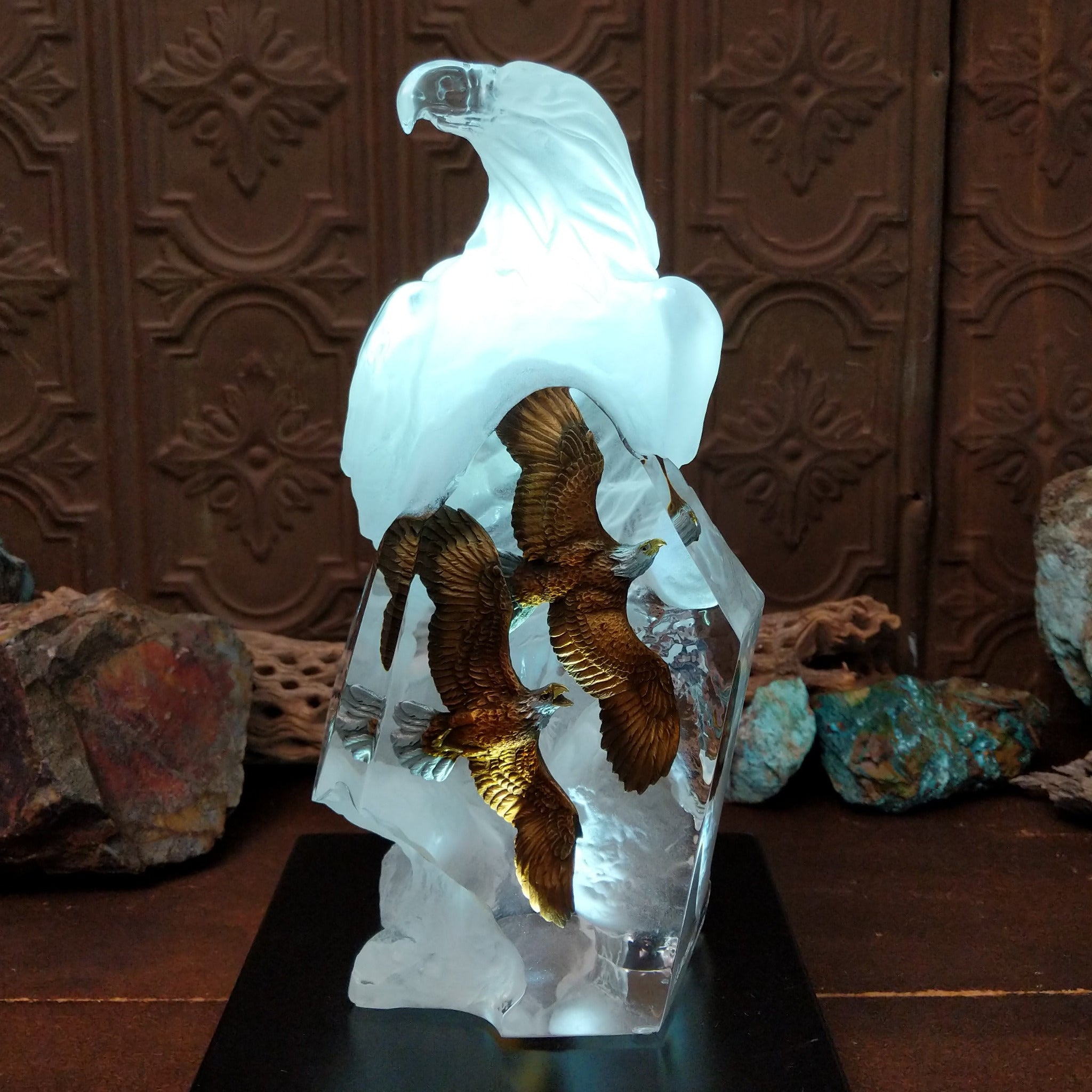 A frosted Lucite sculpture of a bald eagle with two hand-painted bald eagles soaring through the clear crystal interior; low light display.