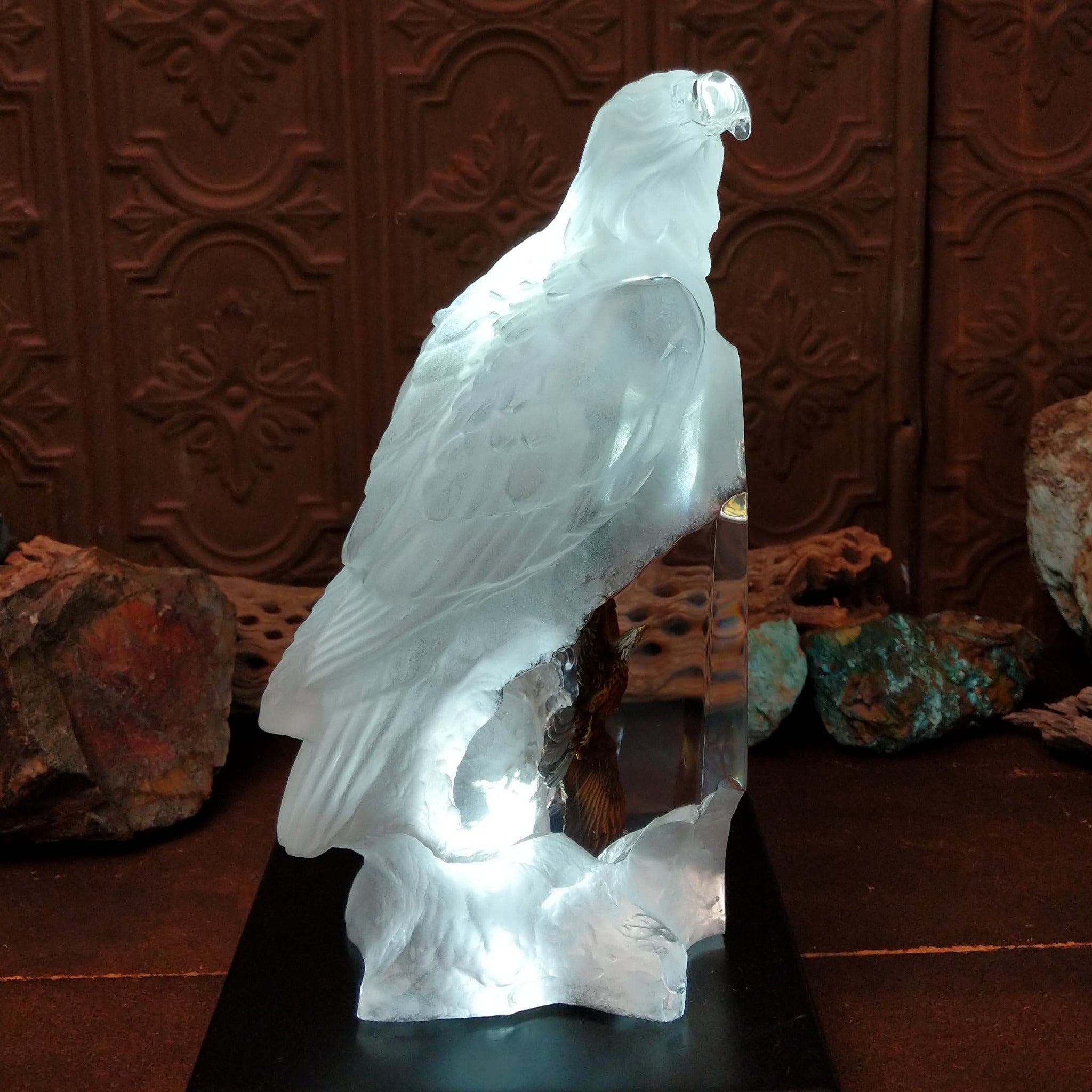 A frosted Lucite sculpture of a bald eagle with two hand-painted bald eagles soaring through the clear crystal interior; low light display.