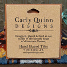Corkboard backing of a hand glazed ceramic tile with artist details.