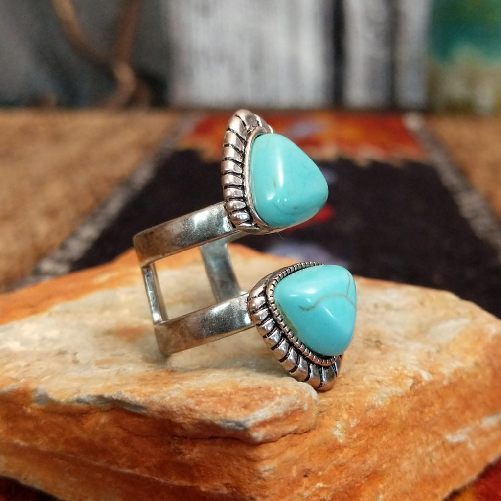 A nickel-free metal ring with a vibrant turquoise-colored stone, framed by a textured scalloped edge.