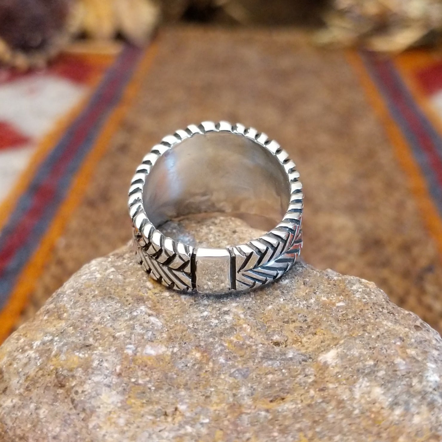 Sterling silver ring with oval malachite set in the bezel and weave patterned band.