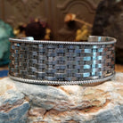 Wide sterling silver cuff bracelet with a woven basketweave pattern and twisted rope borders.
