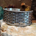 Wide sterling silver cuff bracelet with a woven basketweave pattern and twisted rope borders.