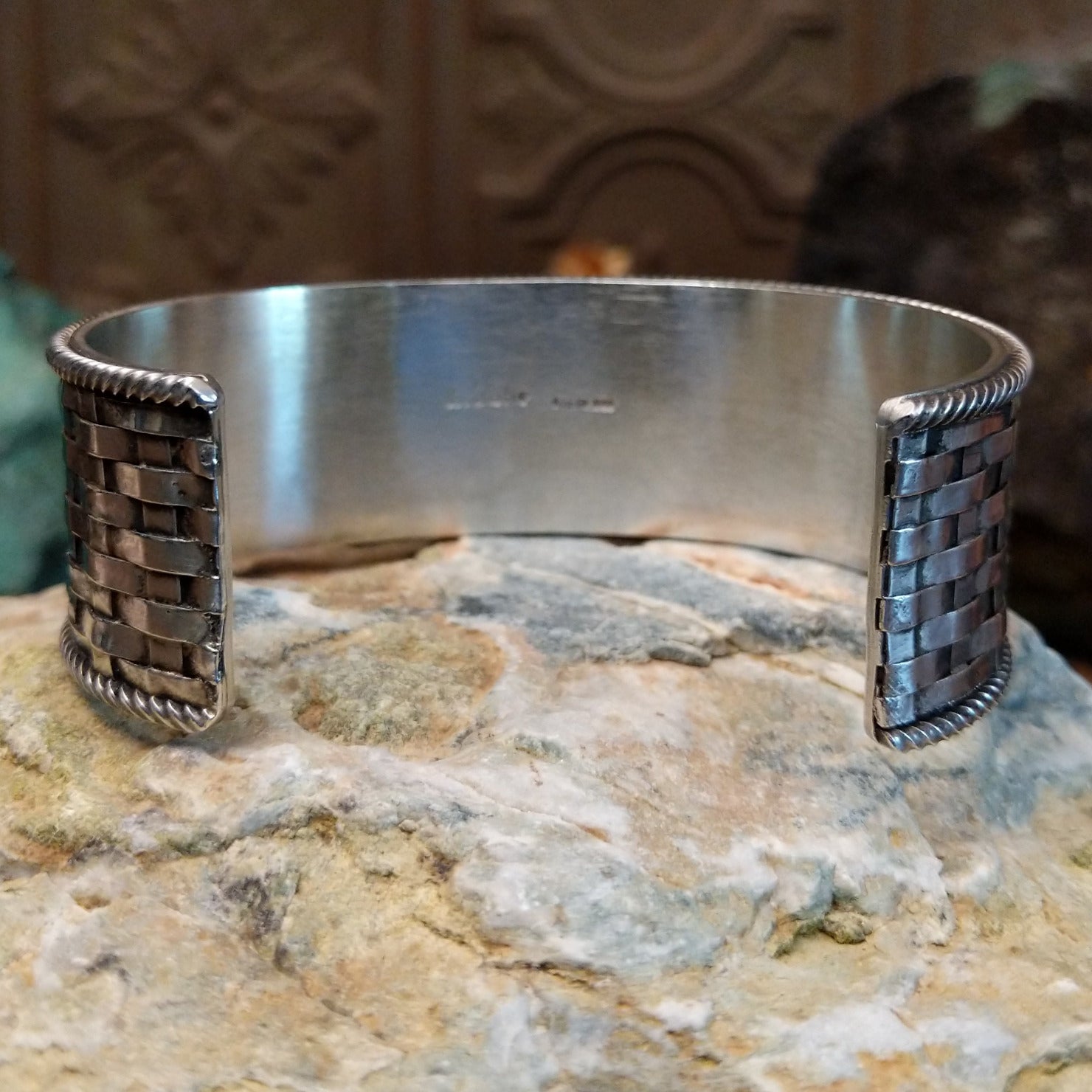Wide sterling silver cuff bracelet with a woven basketweave pattern and twisted rope borders.