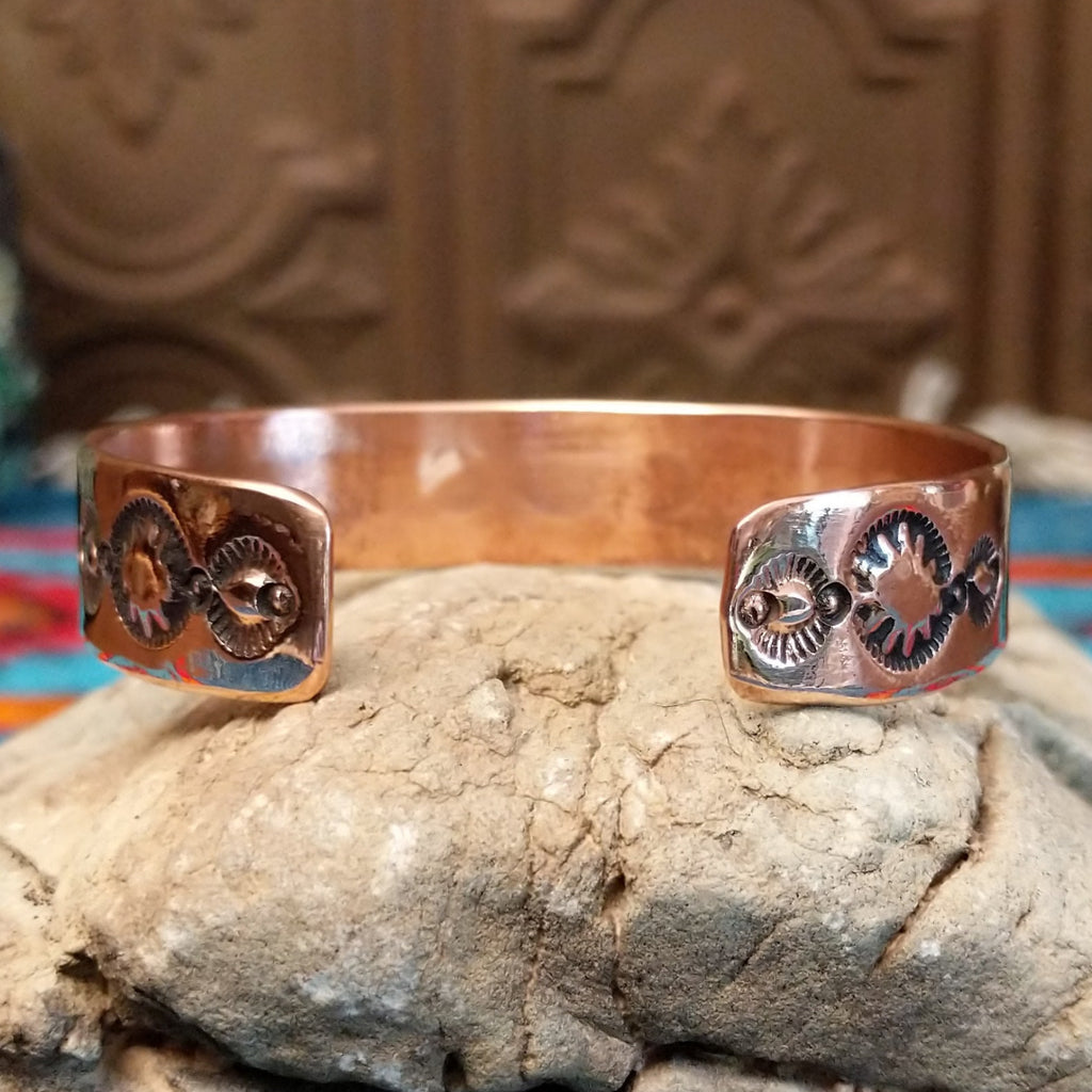 Copper and sterling silver bracelet with whirlwind and horse stamped patterns.