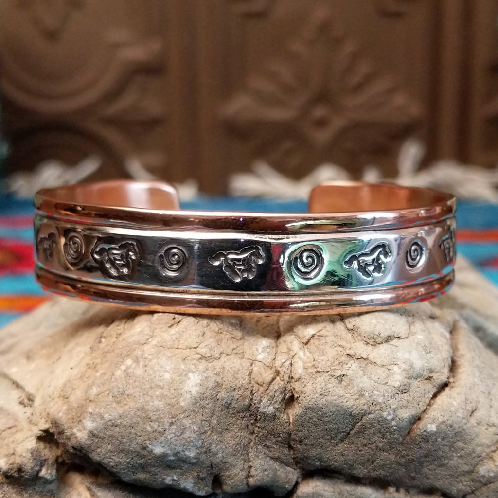 Copper and sterling silver bracelet with whirlwind and horse stamped patterns.