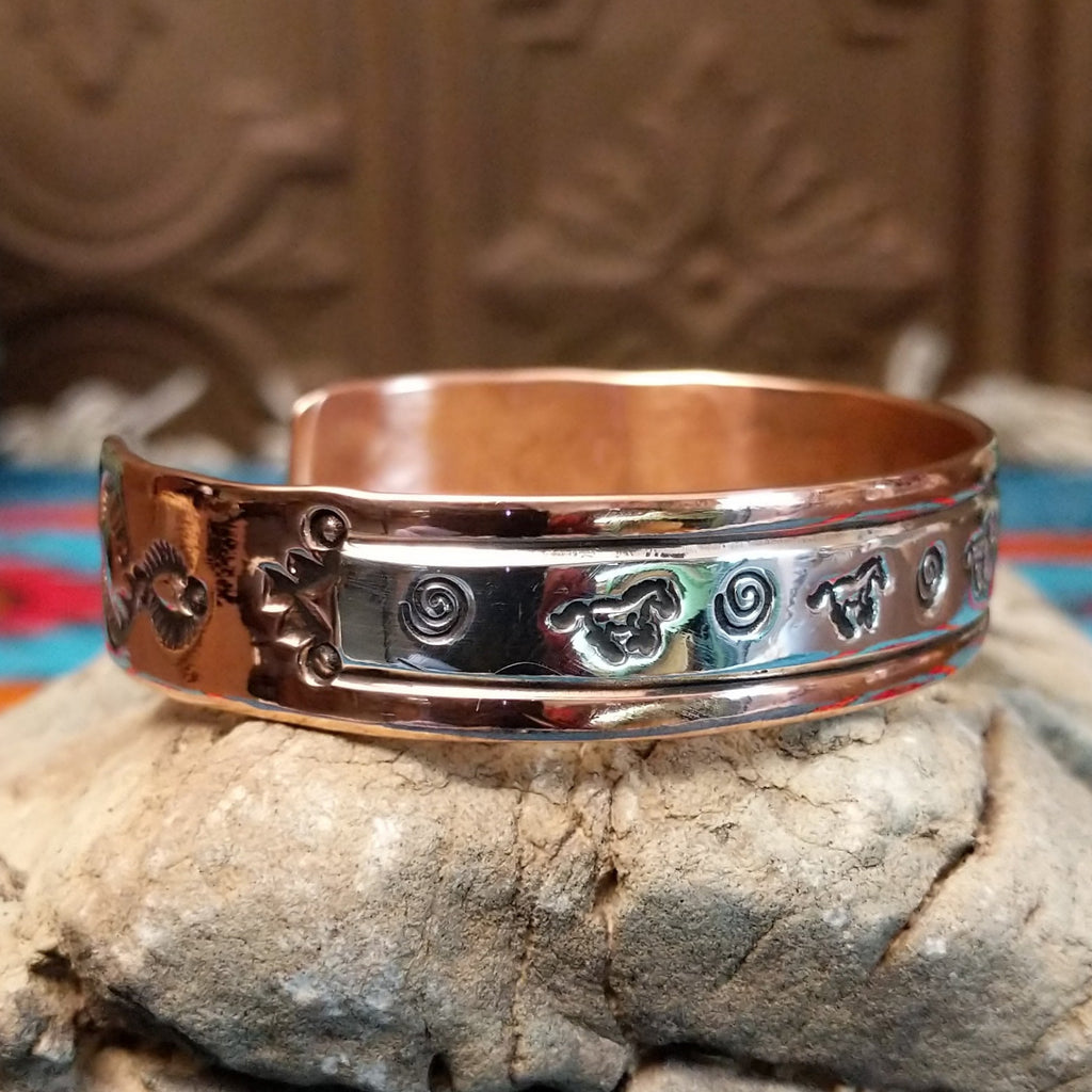 Copper and sterling silver bracelet with whirlwind and horse stamped patterns.