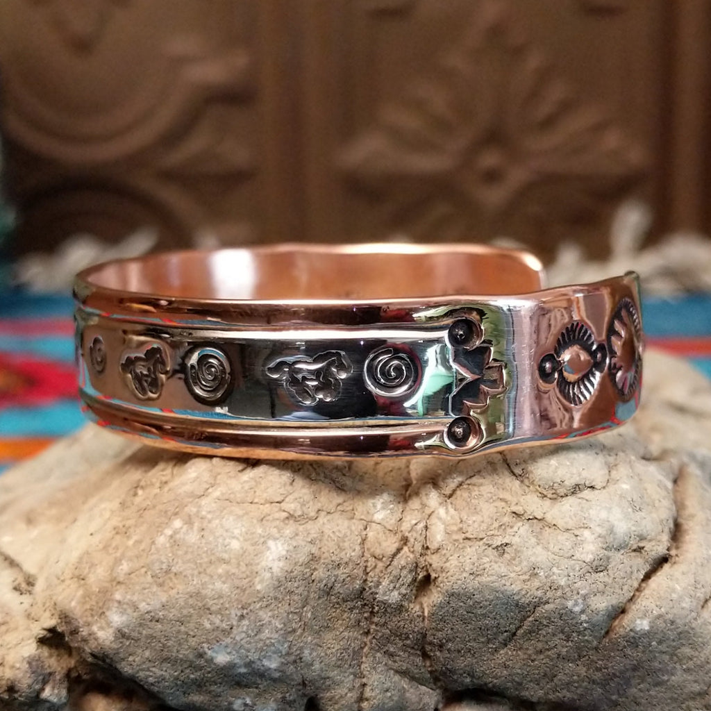 Copper and sterling silver bracelet with whirlwind and horse stamped patterns.