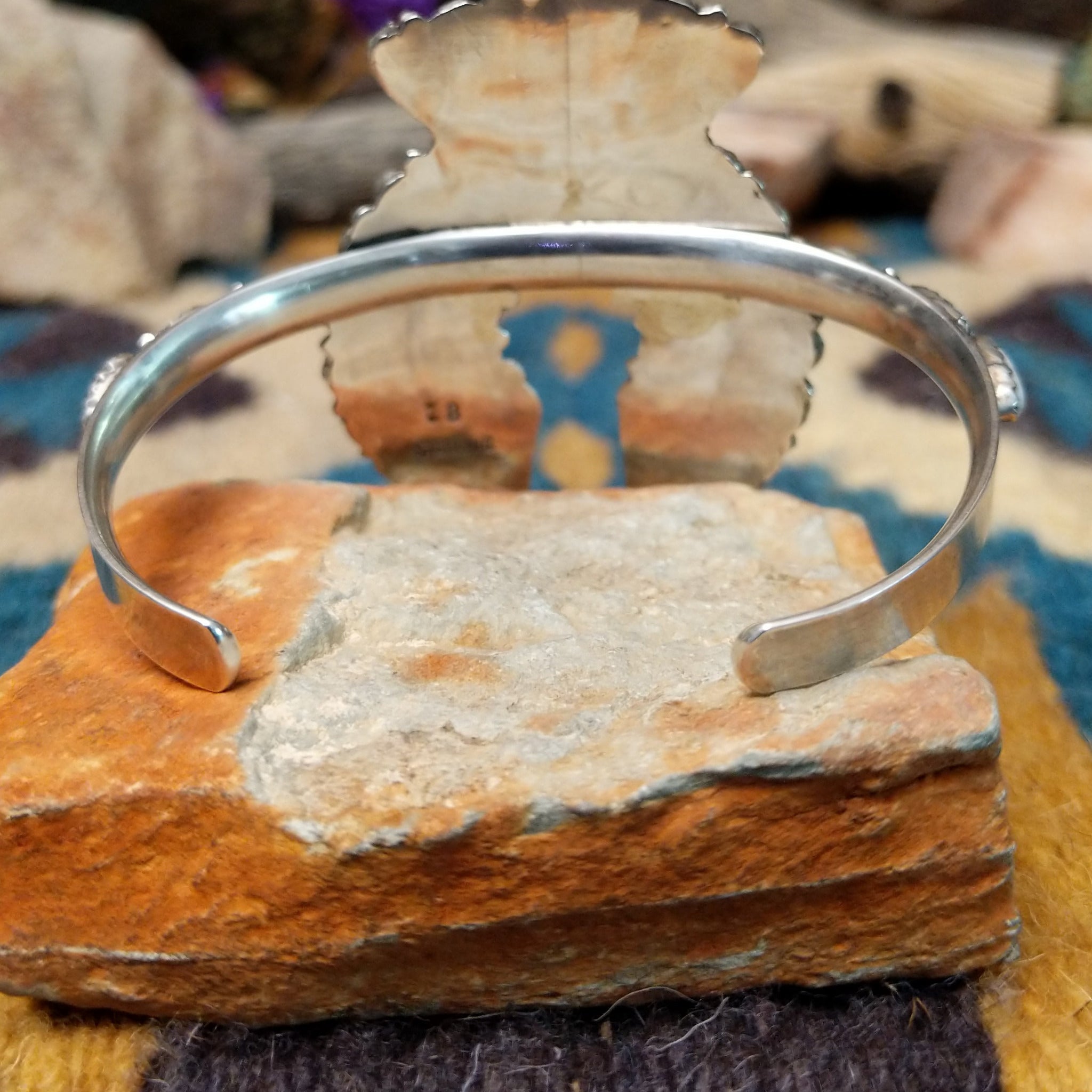 Handcrafted sterling silver Naja cuff by Zeta Begay featuring White Buffalo stones in a fan pattern with twisted rope detailing, silver bead accents, and traditional Navajo craftsmanship; underside view.