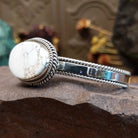 Sterling silver cuff featuring a White Buffalo stone set in a twisted rope bezel.