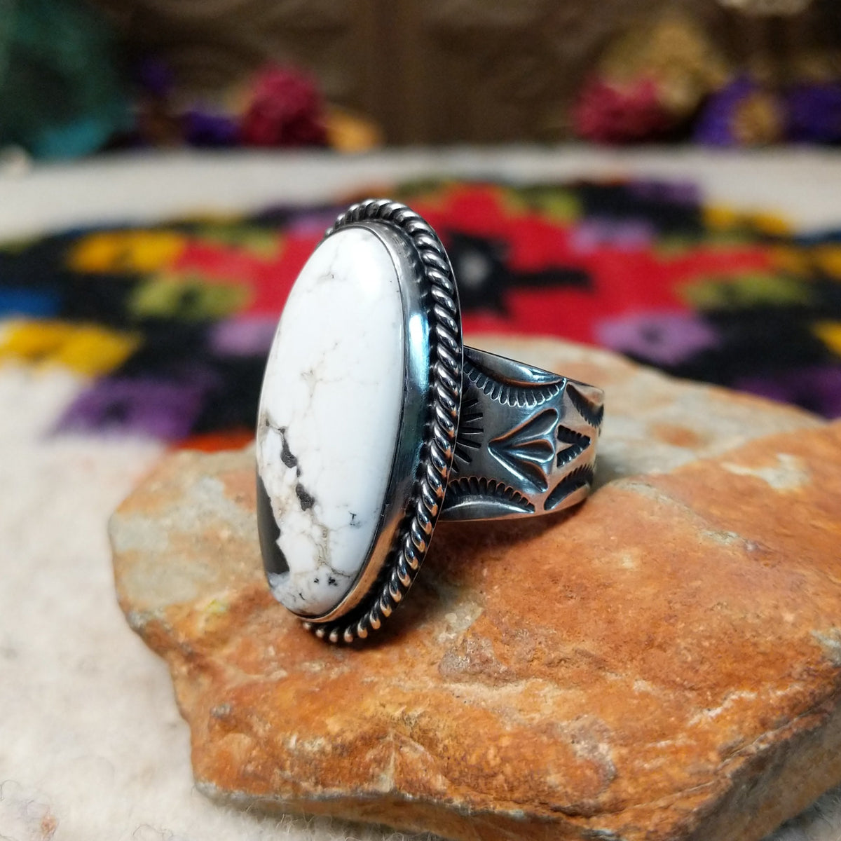 White Buffalo Oval Ring by Angel Martin & Bernyse Chavez with a large black-and-white stone set in a twisted rope-style sterling silver frame; side view.