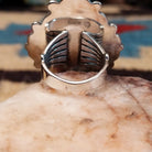 Sterling silver ring features white buffalo set in oval bezel with filigree pattern.