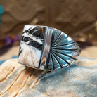 Sterling silver ring with white buffalo set in a rectangular bezel and stamped designs on the band.
