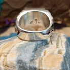 Sterling silver ring with white buffalo set in a rectangular bezel and stamped designs on the band.