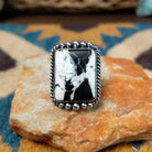 Handcrafted sterling silver White Buffalo ring by Alfred Martinez, featuring a rectangular White Buffalo gemstone with a twisted rope border and silver bead accents.
