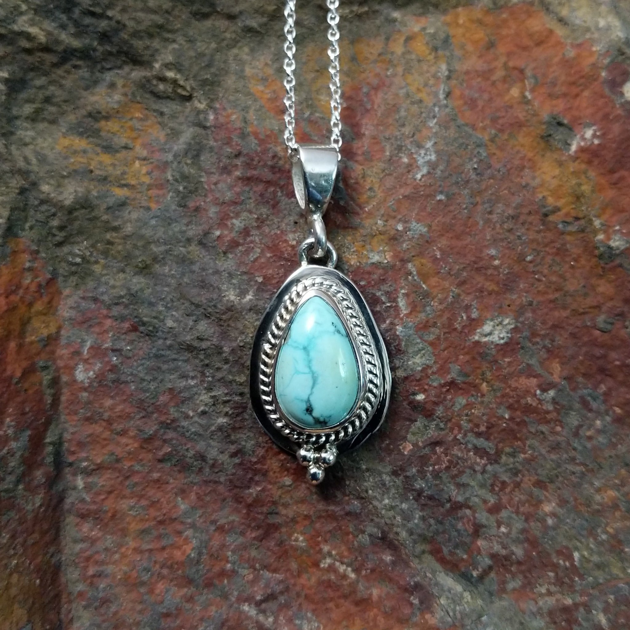 Handcrafted sterling silver White Water turquoise pendant by Lucy Jake, featuring a natural blue-green stone in a traditional Navajo setting.