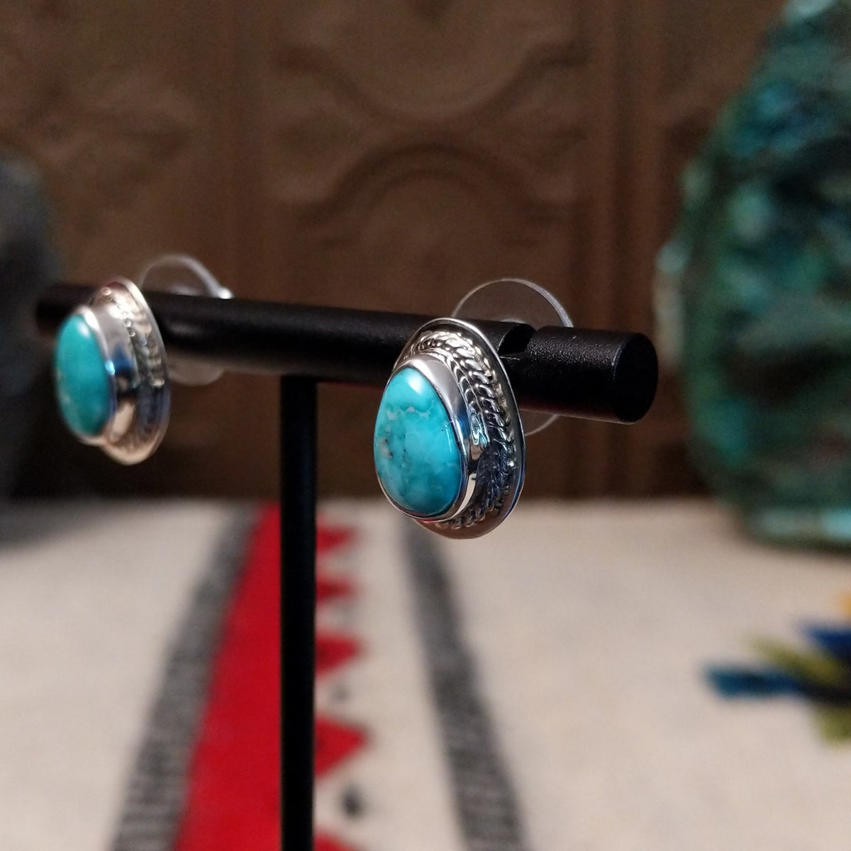 Whitewater turquoise stud earrings by L.P. featuring teardrop-shaped turquoise stones with natural matrix set in polished sterling silver with twisted rope detailing; side view.