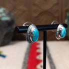 Whitewater turquoise stud earrings by L.P. featuring teardrop-shaped turquoise stones with natural matrix set in polished sterling silver with twisted rope detailing; side view.