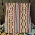 Wide Ruins Navajo rug by Irma Francis with vertical striped and diamond patterns in tan, brown, cream, muted blue, and golden yellow.