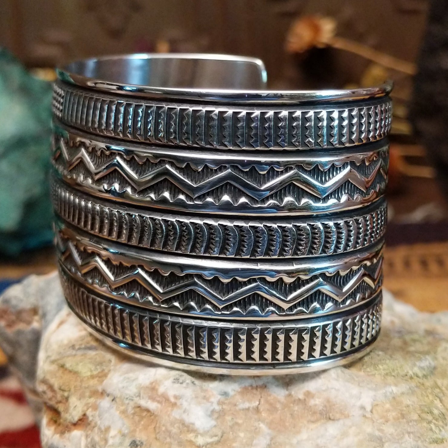 Sterling silver cuff bracelet with raised zigzag motifs and hand-stamped decorative bands.