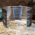 Sterling silver cuff bracelet with raised zigzag motifs and hand-stamped decorative bands.