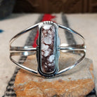 Silver cuff by Amory Begay featuring a long rectangular Wild Horse stone with creamy white and brown matrix, framed by polished silver and curved split bands.