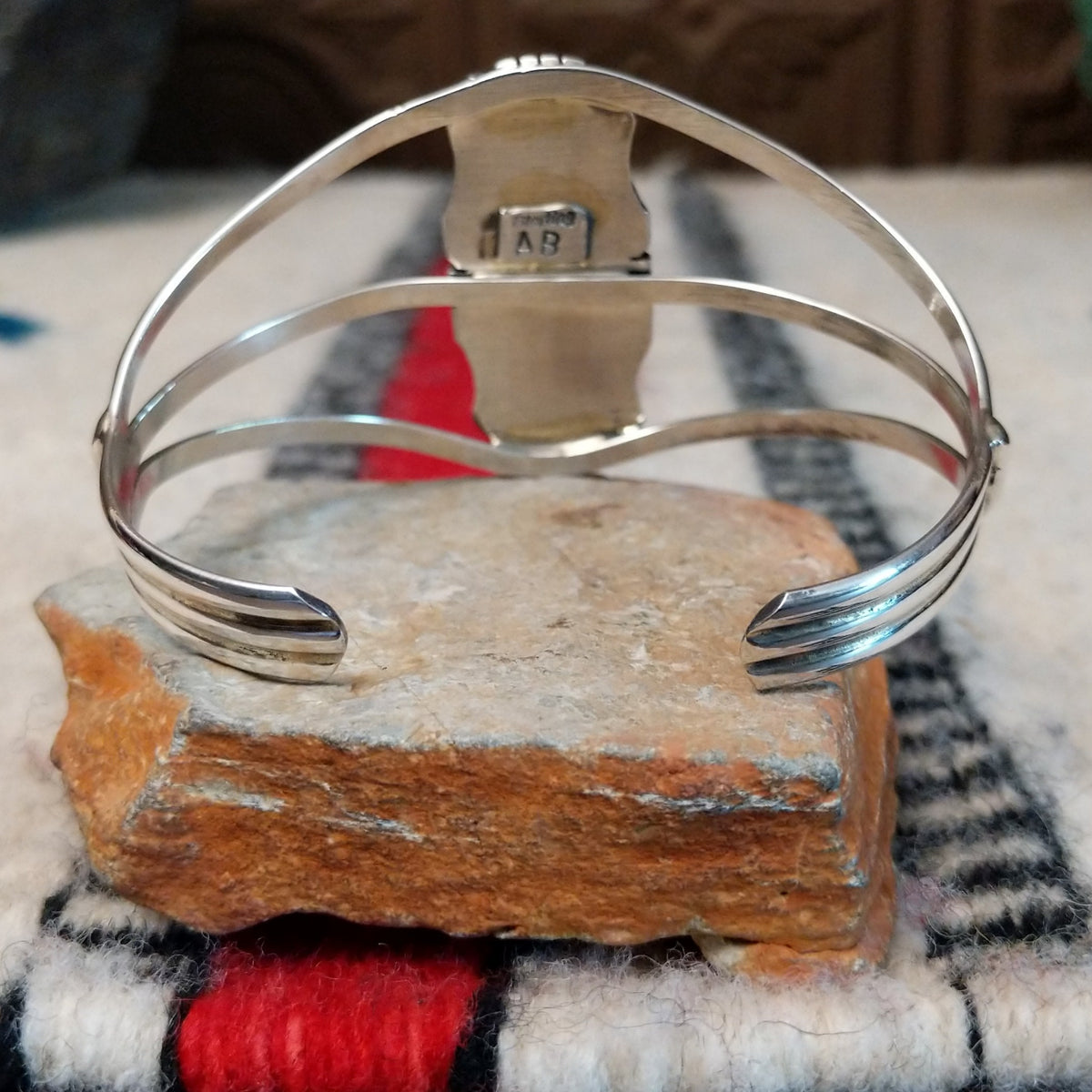 Silver cuff by Amory Begay featuring a long rectangular Wild Horse stone with creamy white and brown matrix, framed by polished silver and curved split bands; underside view.