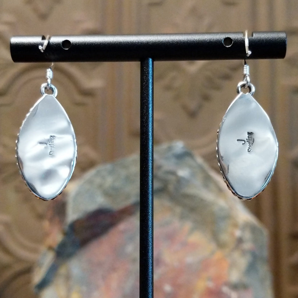 The back of the earrings feature polished silver and signature stamp.
