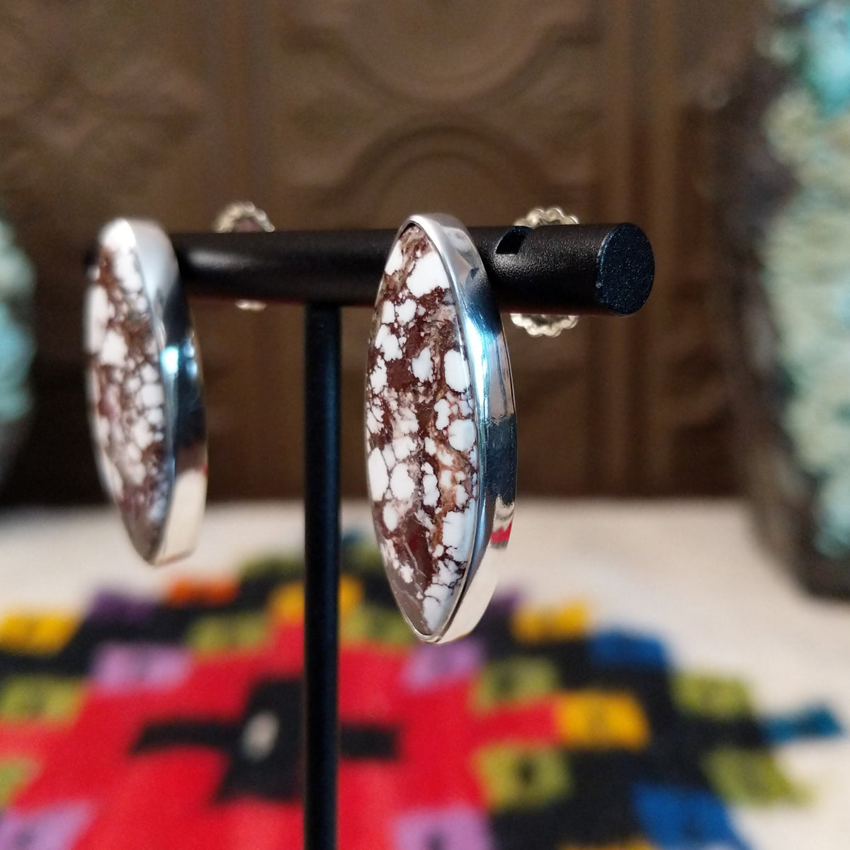 Wild Horse Earrings by Diane Wylie featuring elongated navette-shaped stones with white and reddish-brown matrix patterns set in smooth silver bezels; side view.