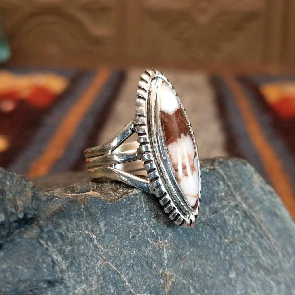 A wild horse stone within a sterling silver navette ring, framed by a serrated edge and polished band.