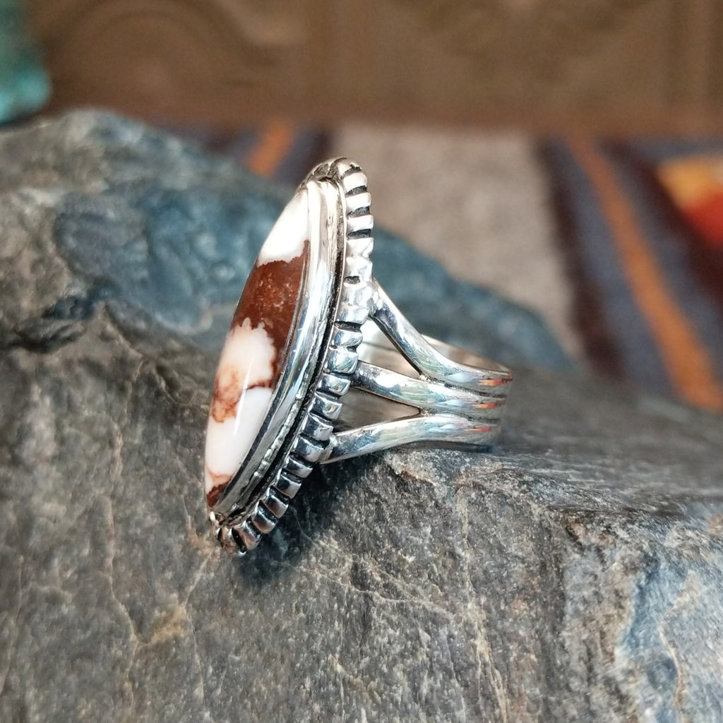 A wild horse stone within a sterling silver navette ring, framed by a serrated edge and polished band.