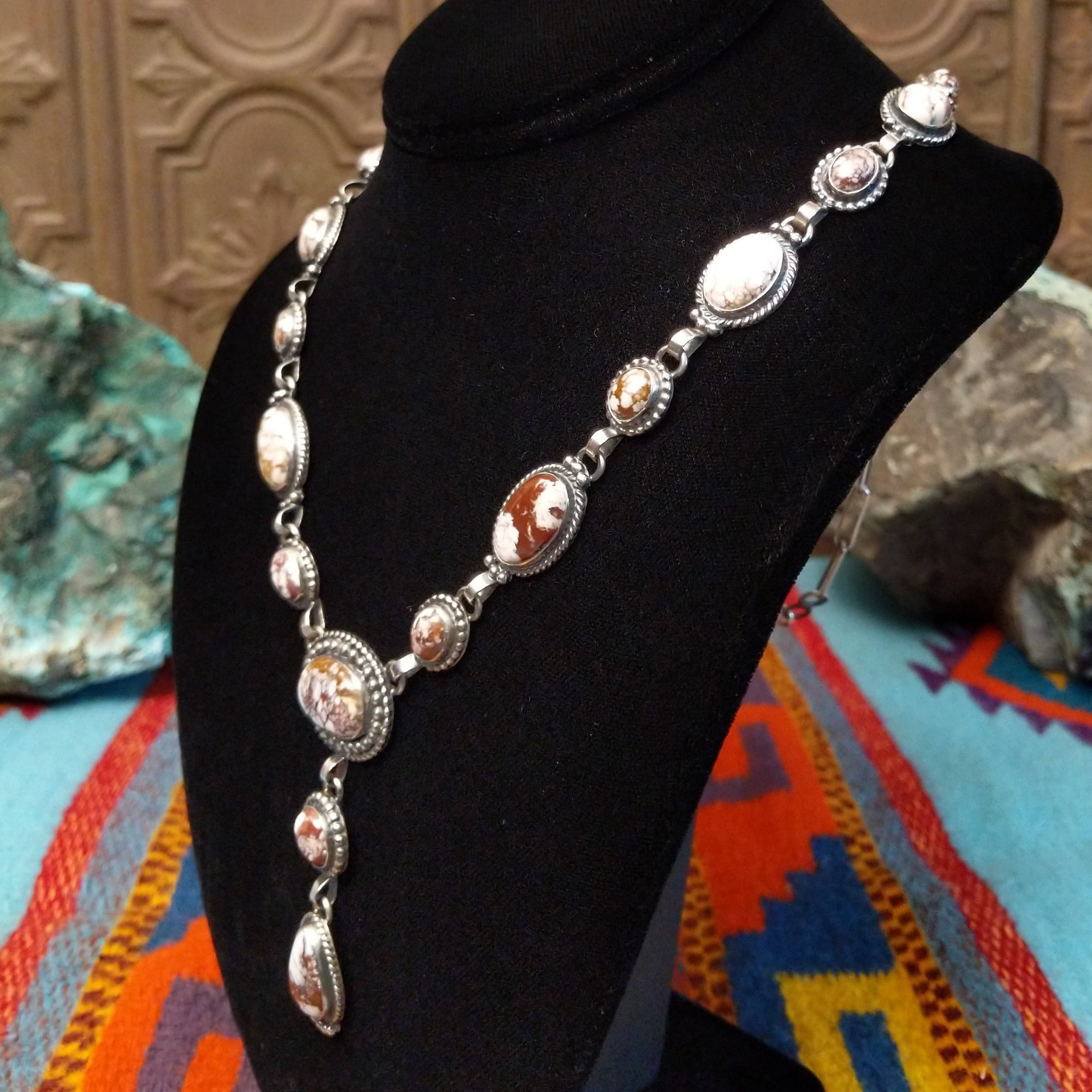 Wild Horse Sterling Silver necklace  by Mary Ellen, featuring natural white, cream, brown, and reddish matrix stones in an intricate handcrafted design; side veiw.