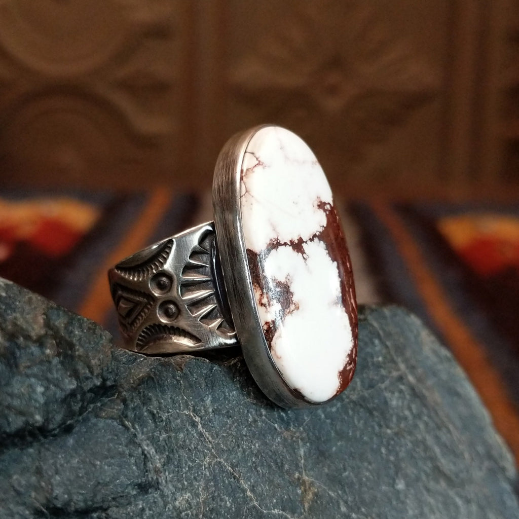 Wild horse ring with brown and white matrix set in a smooth bezel and intricately stamped band.