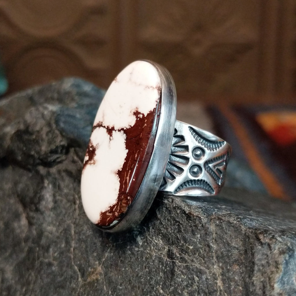 Wild horse ring with brown and white matrix set in a smooth bezel and intricately stamped band.