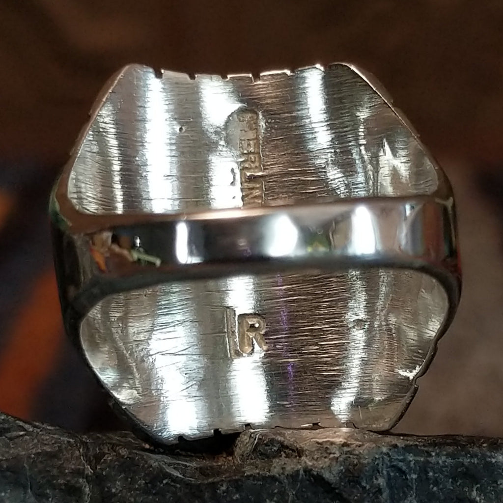 The artist's signature is found on the underside of the bezel.