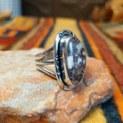 Opposite side view of a Wild Horse stone ring featuring a raised oval bezel setting, decorative stamped silver border, and polished triple split-shank band.