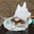 A frosted Lucite sculpture shaped like a wolf's head with a hand-painted wolf running inside the clear crystal interior, creating the illusion of movement.