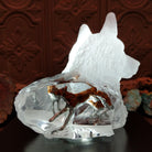 A frosted Lucite sculpture shaped like a wolf's head with a hand-painted wolf running inside the clear crystal interior, creating the illusion of movement; lower light display.
