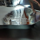 A frosted Lucite sculpture shaped like a wolf's head with a hand-painted wolf running inside the clear crystal interior, creating the illusion of movement; artisan signature and production number.