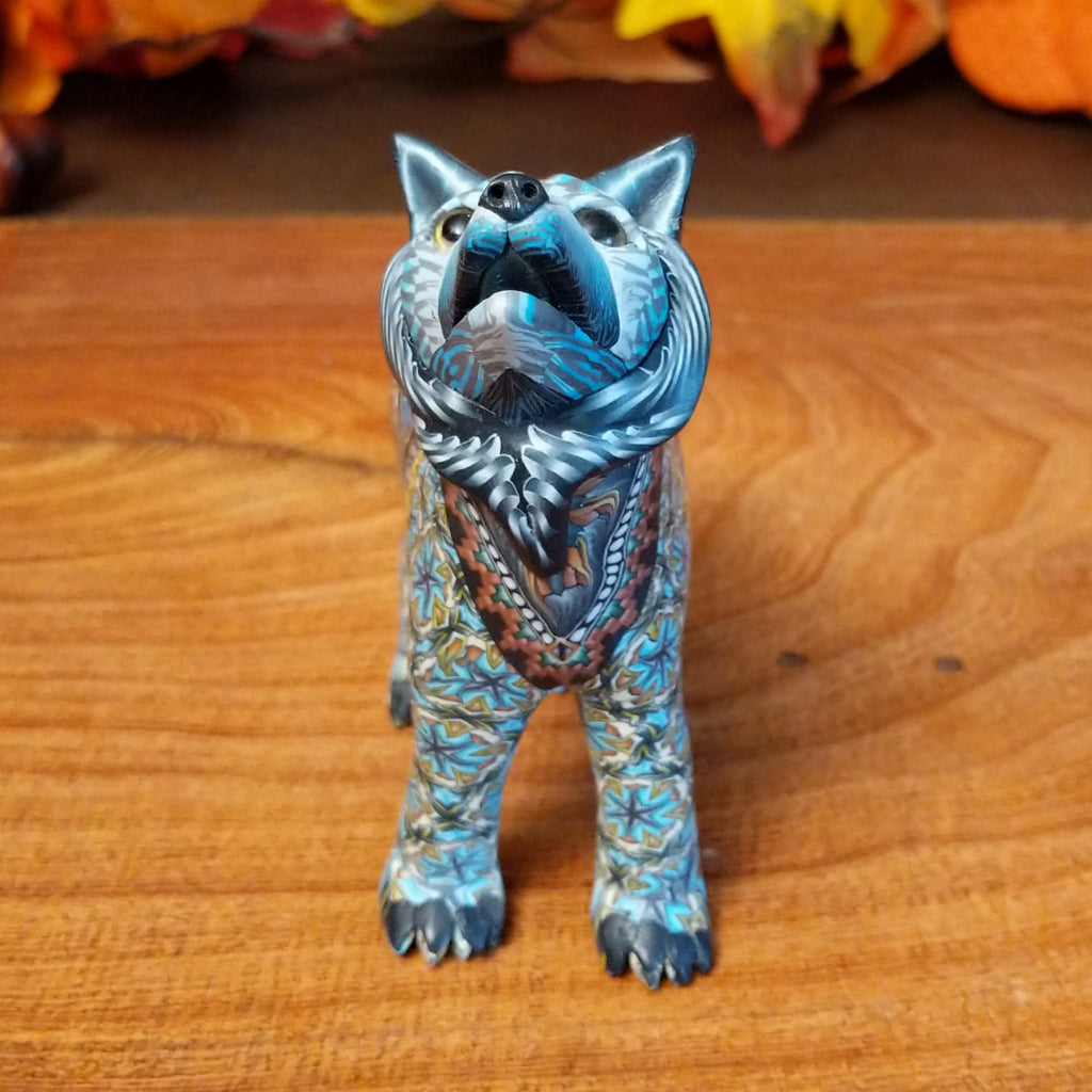 Polymer clay used to create a standing wolf with geometric and floral designs on its body.