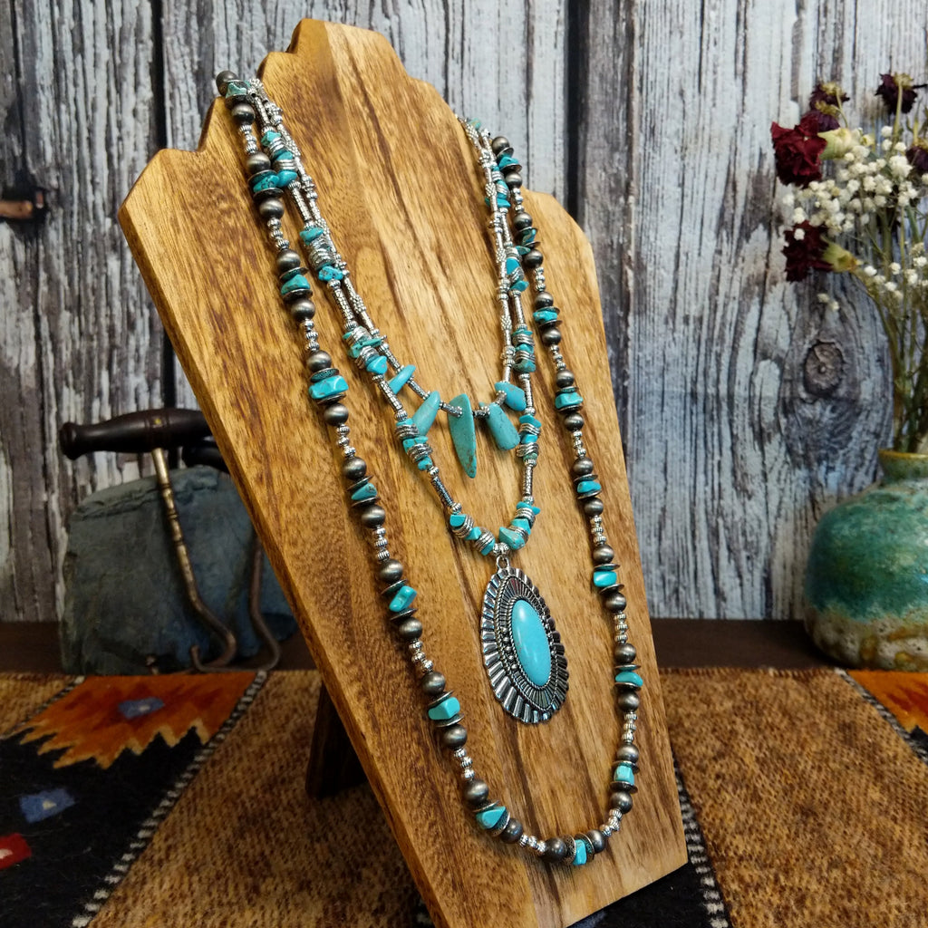 Necklace with a large turquoise pendant and nickel-free metal beads, layered with additional turquoise accents.