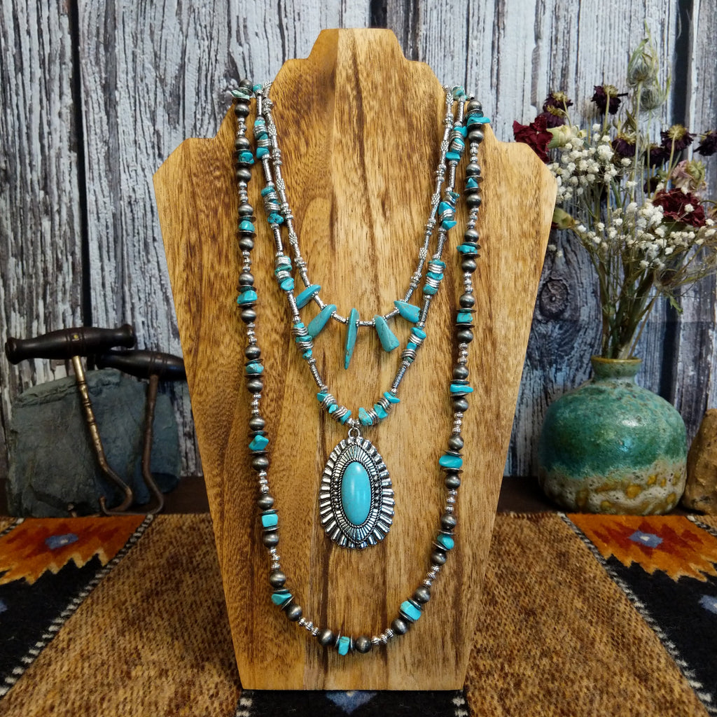 Necklace with a large turquoise pendant and nickel-free metal beads, layered with additional turquoise accents.