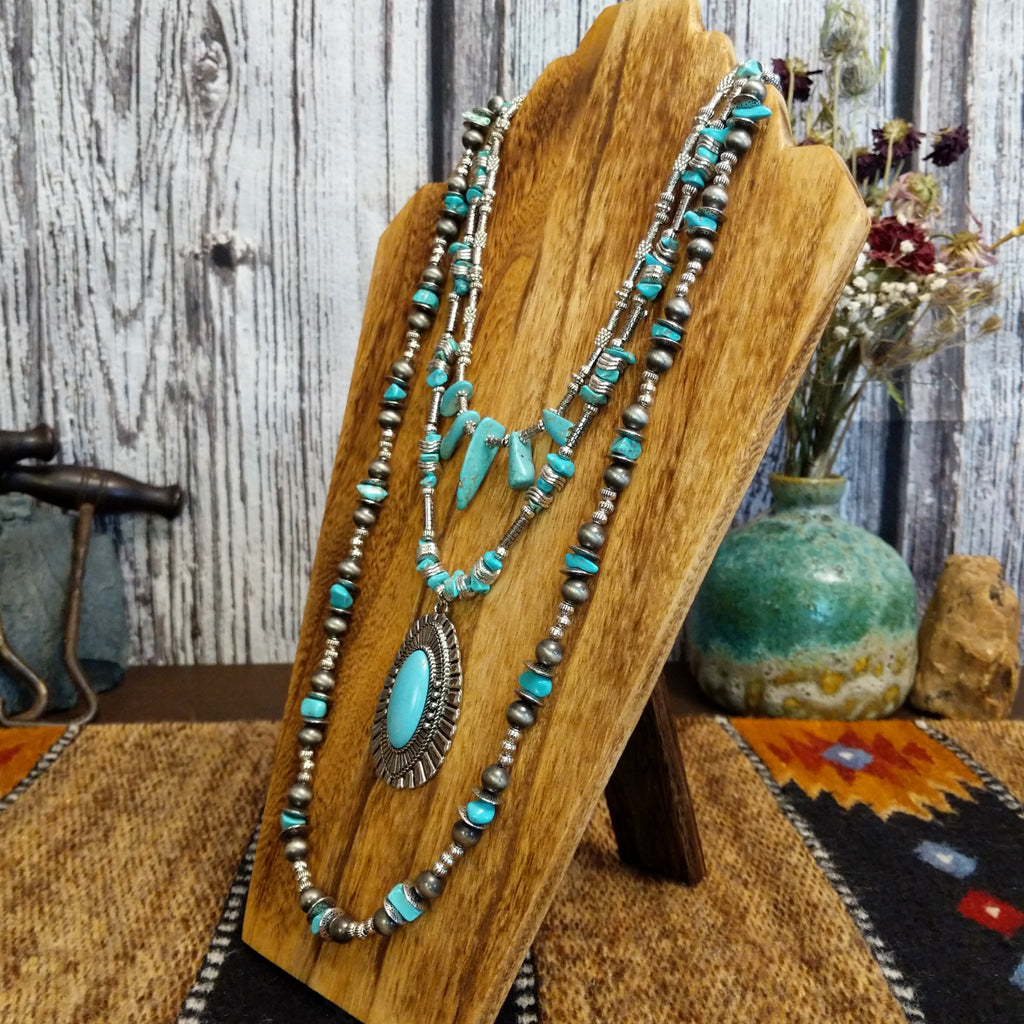 Necklace with a large turquoise pendant and nickel-free metal beads, layered with additional turquoise accents.