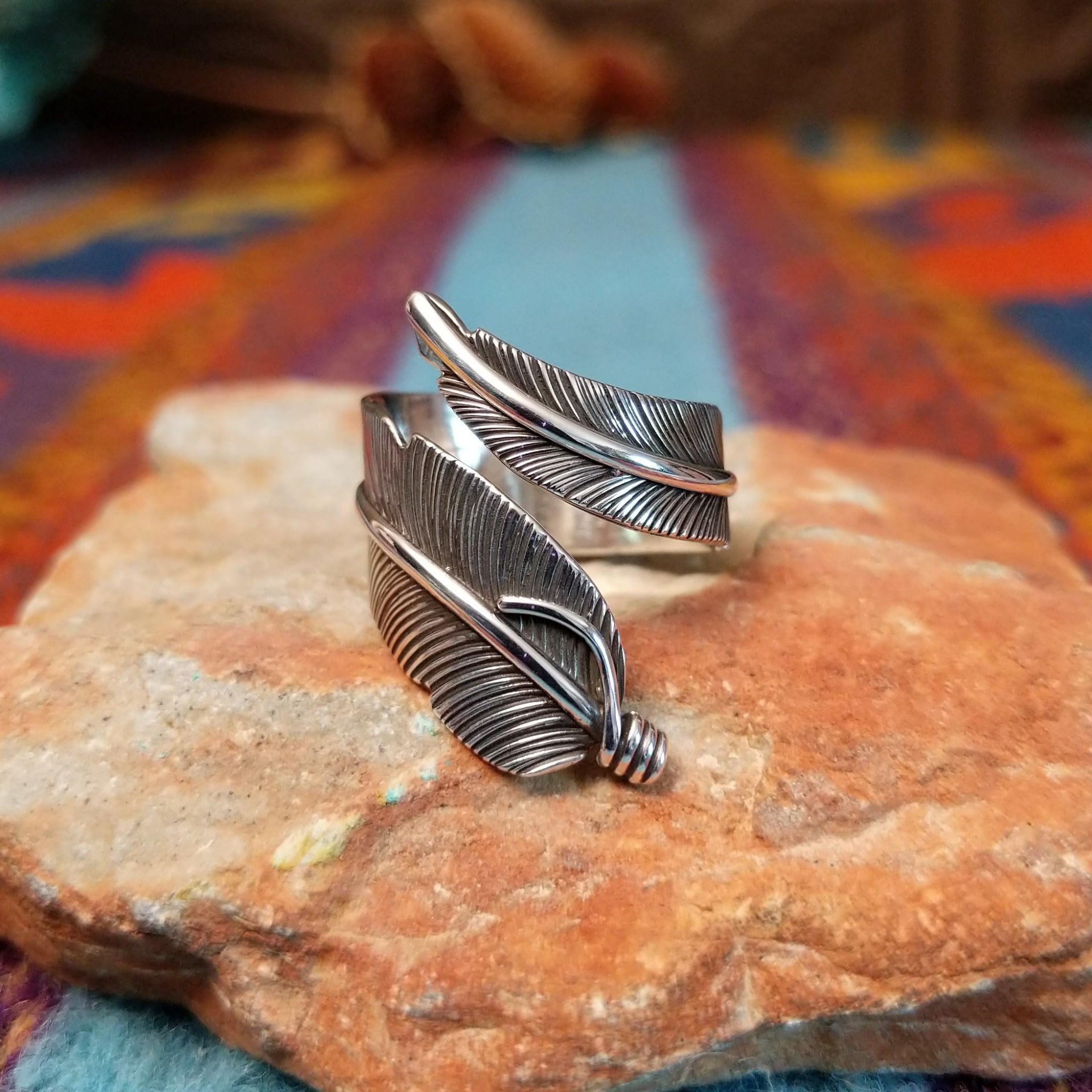 Wrapped silver feather ring by Lena Platero with detailed linework and overlapping design.